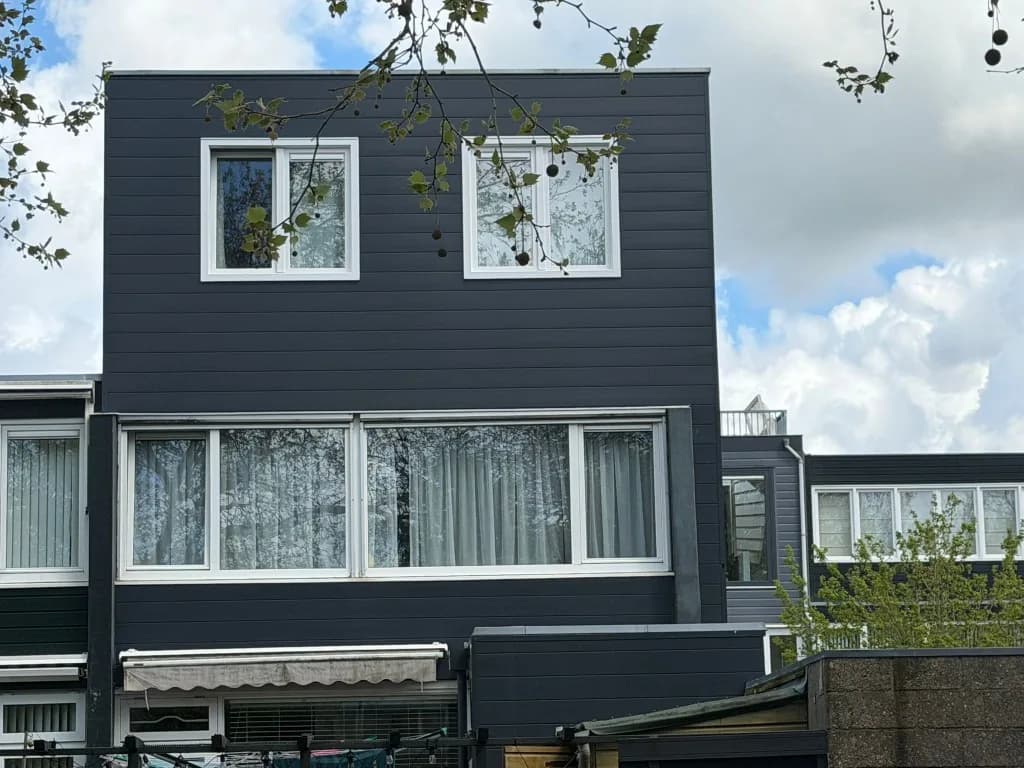 Achtergevel van rijtjeswoning met donkere opbouw en witte kozijnen