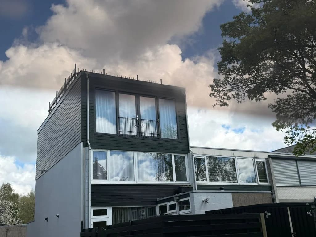 Moderne donkere opbouw op rijtjeswoning met extra verdieping en grote ramen