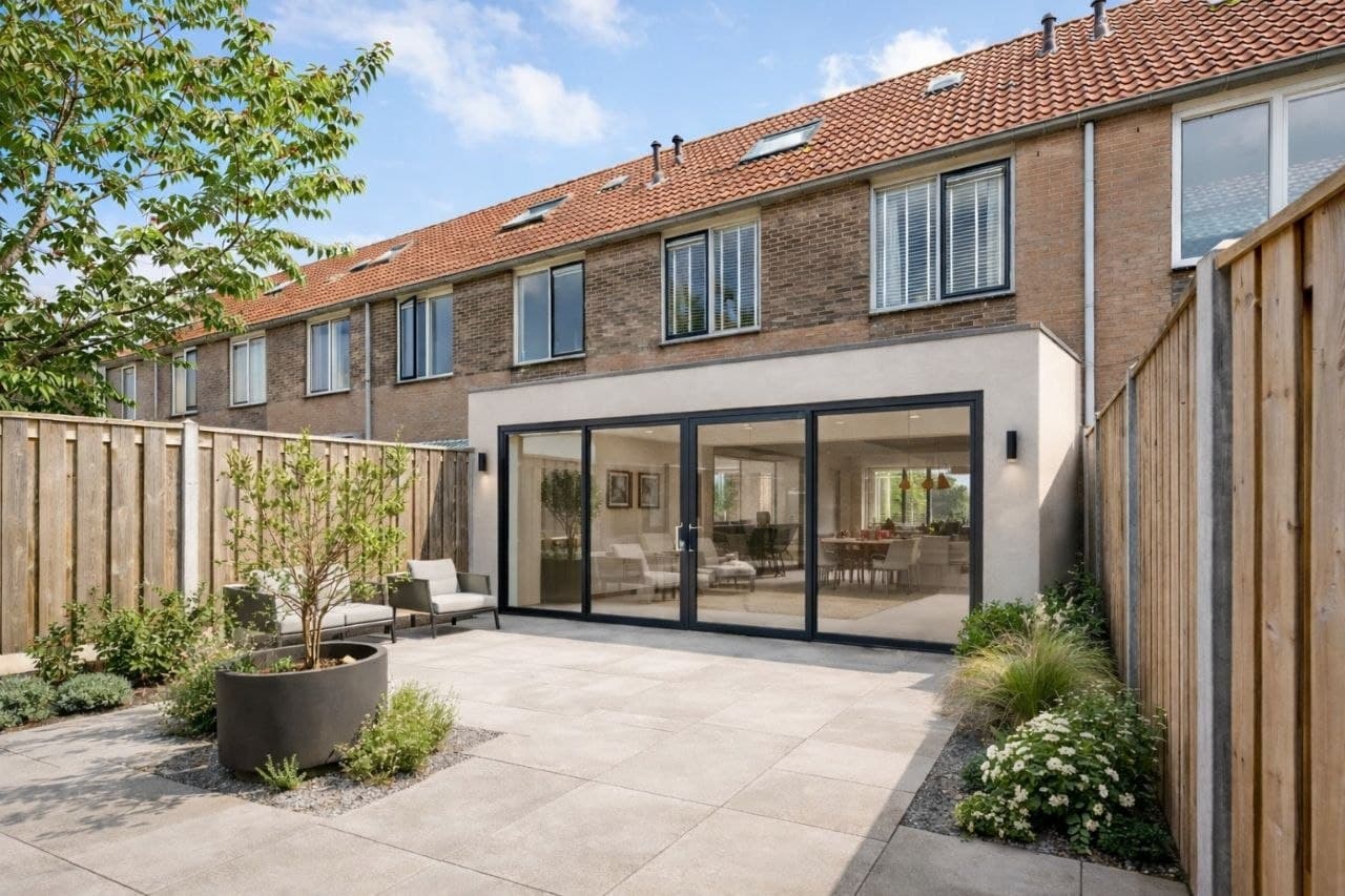 Moderne aanbouw met grote glazen schuifpui aan een Nederlands rijtjeshuis